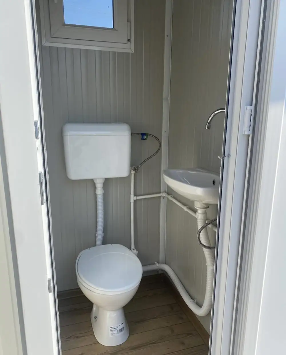 Inside a flushing restroom unit with a sink