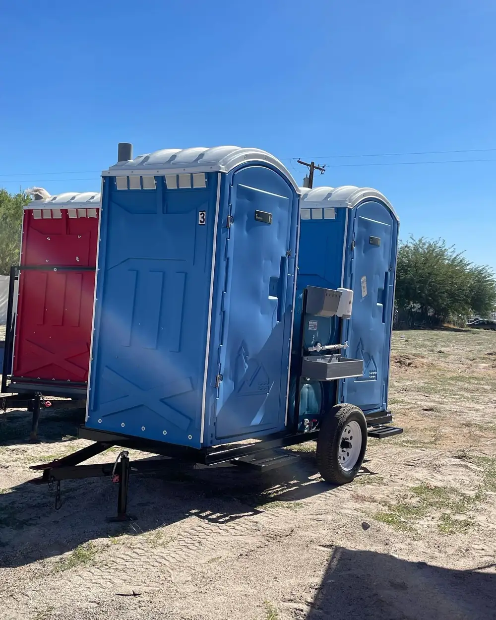 Porta potties strapped onto a delivery trailer