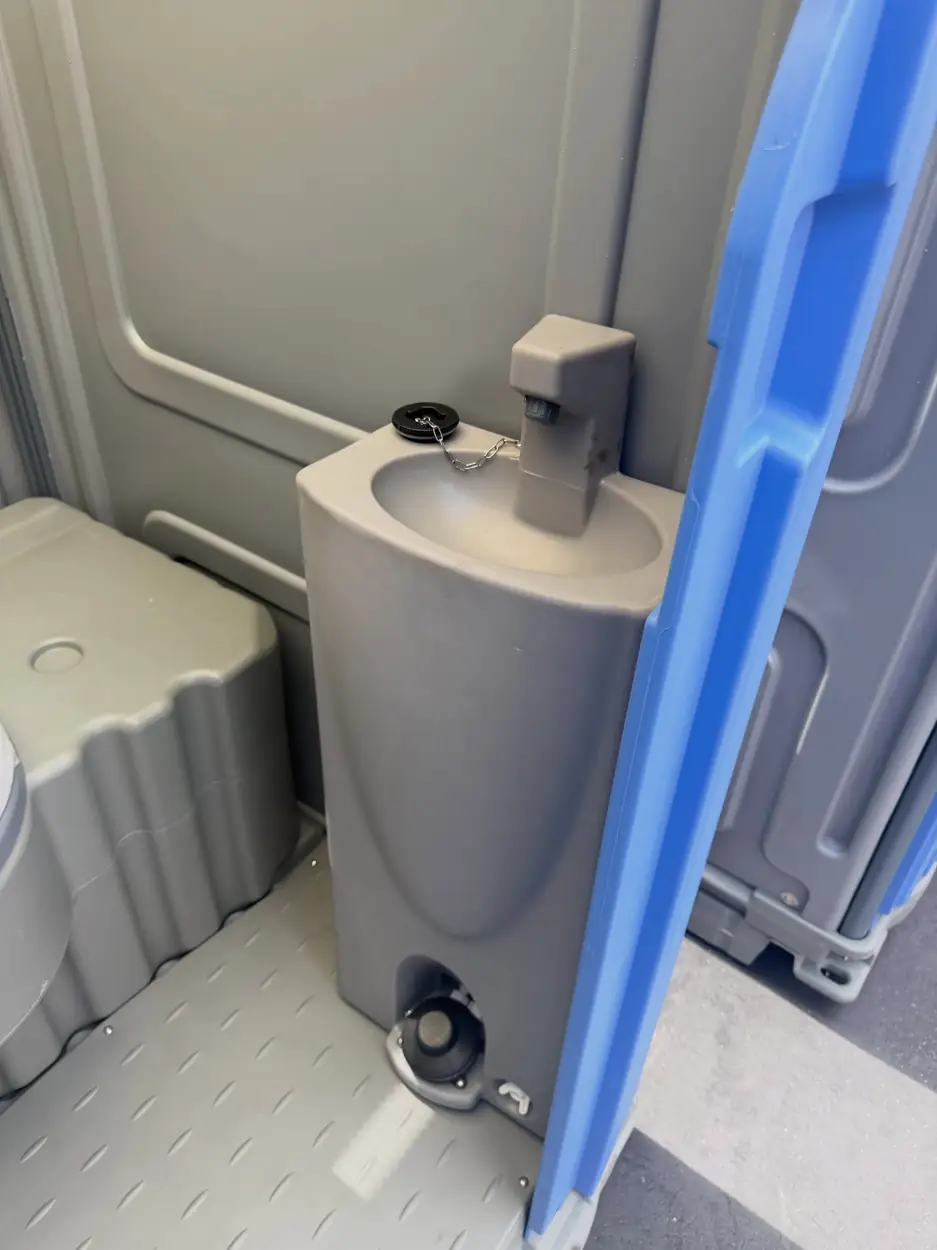Portable toilet with a built-in sink